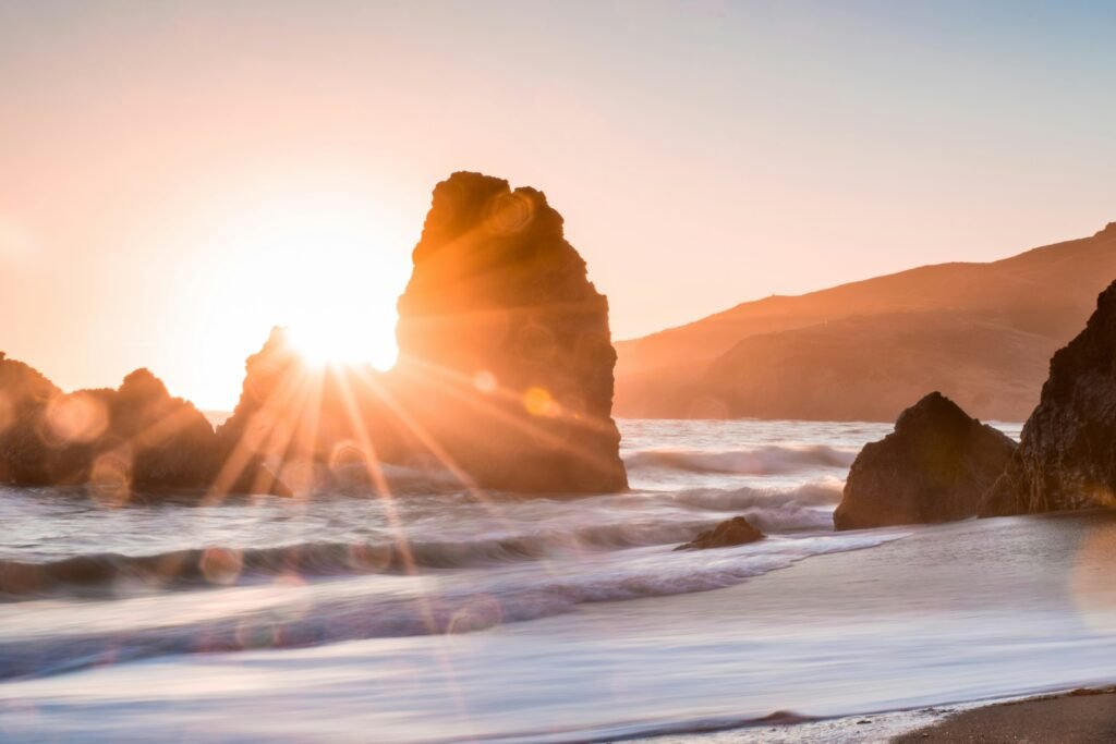 inspiring-sunrise-through-rocks-ocean-beach